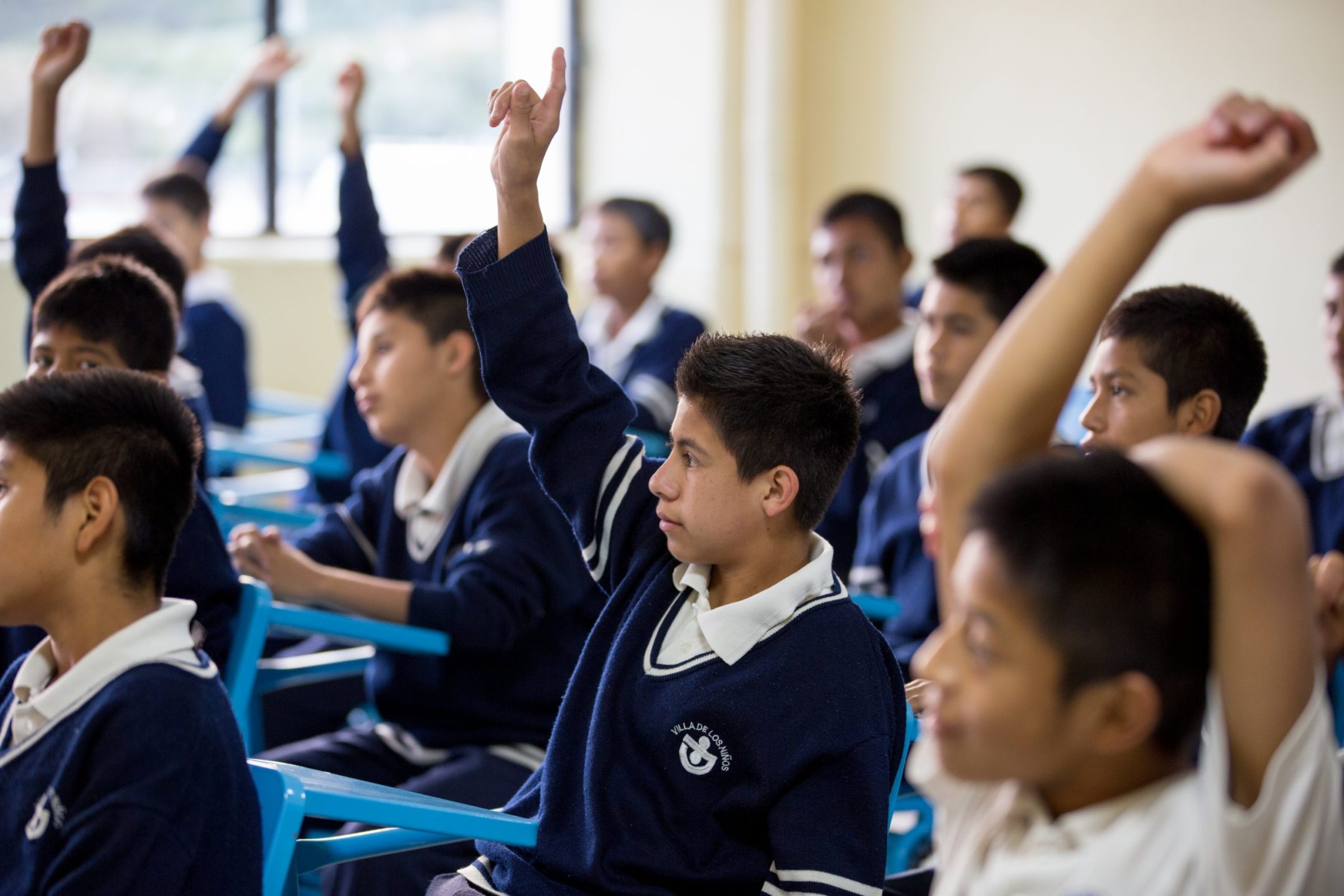 Kind steekt hand op in klas